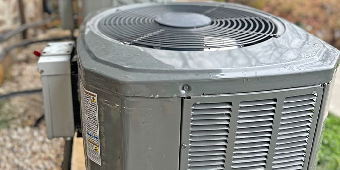 Outdoor air conditioning unit in a backyard setting.