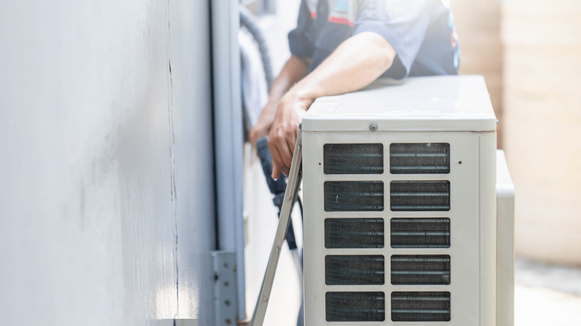 Technician installing an air conditioning unit outside.