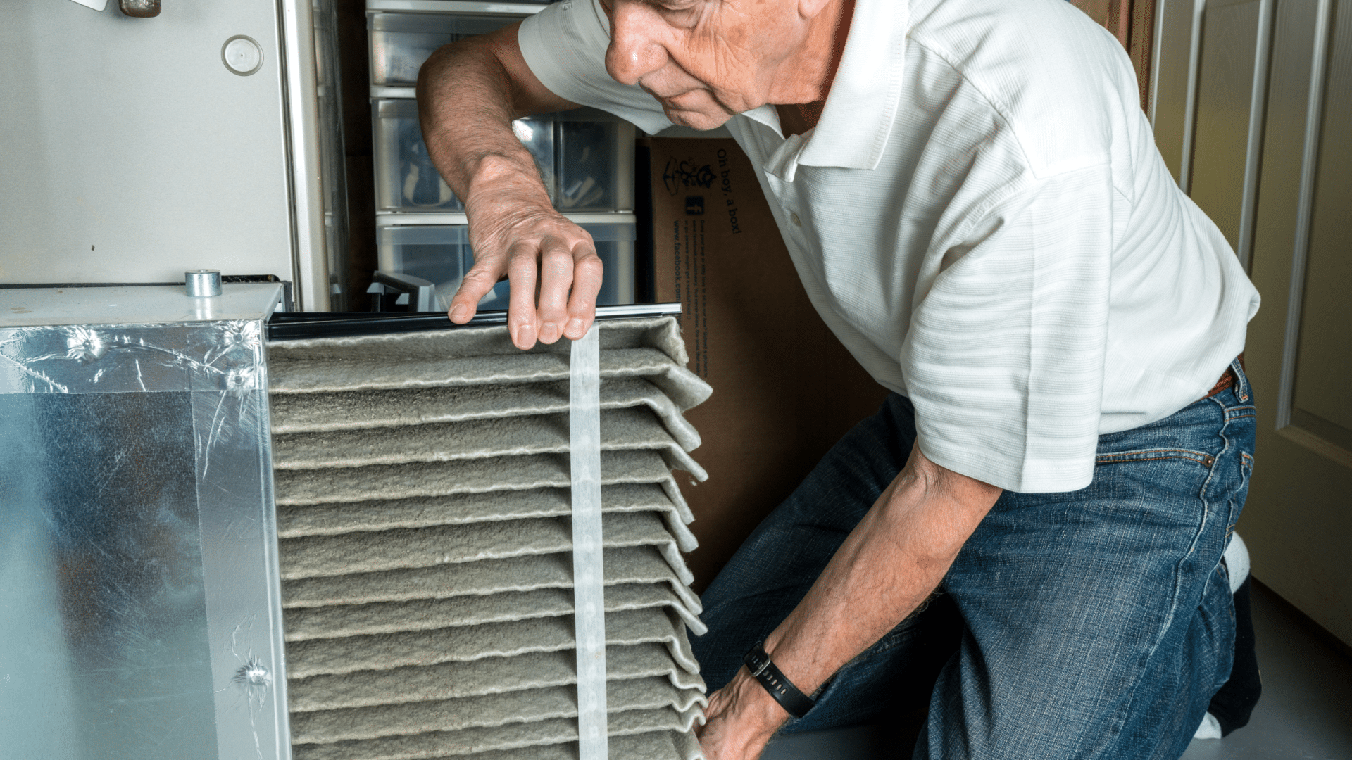 Person installing a furnace air filter at home.