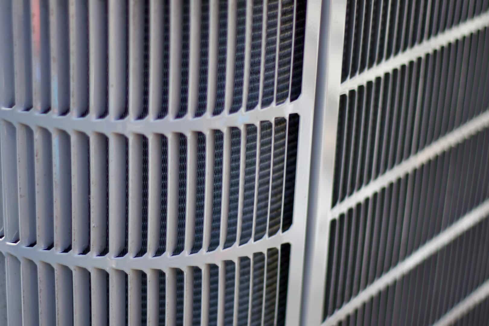 Close-up of an air conditioning unit with metal grille and fins.