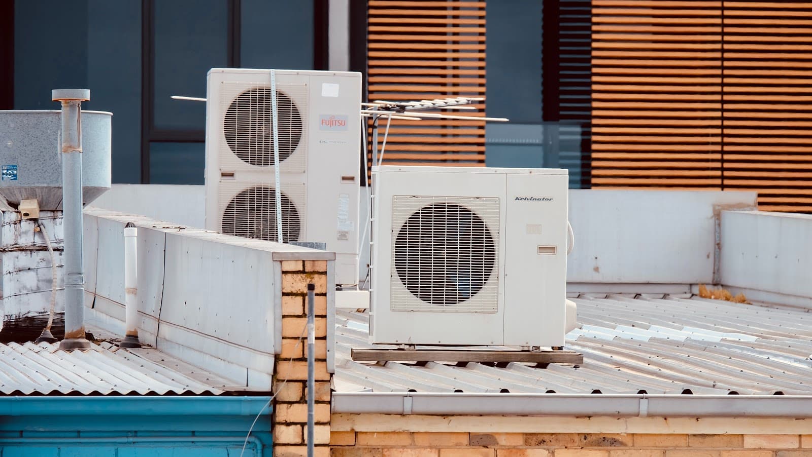 Rooftop air conditioning units on a commercial building with blue sky background.