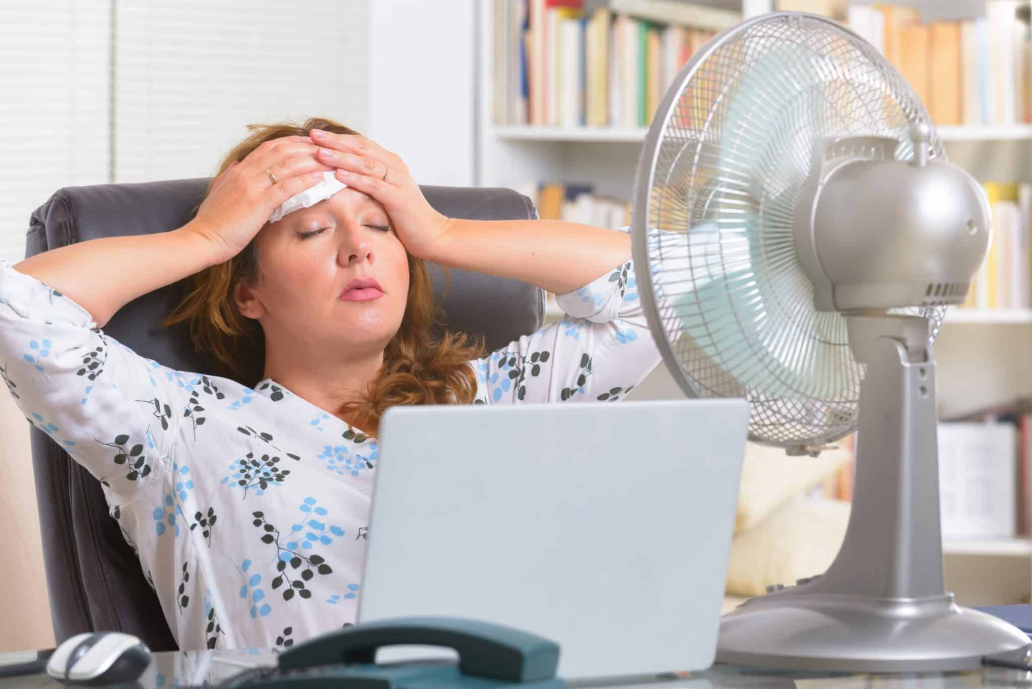 A woman suffers in the heat at home with no AC, a sign of an air conditioning emergency in Tennessee.