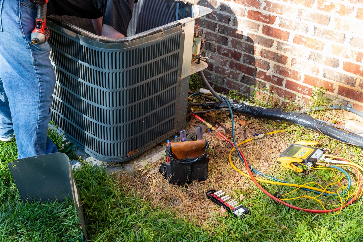 Fall leaves collect on an outdoor HVAC unit, a sign it is time to schedule fall HVAC maintenance in Tennessee.